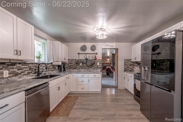 8780 Dixie Hwy, Birch Run, MI 48415 - kitchen with appliances with stainless steel finishes, tasteful backsplash, white cabinetry, light wood finished floors, and light stone counters