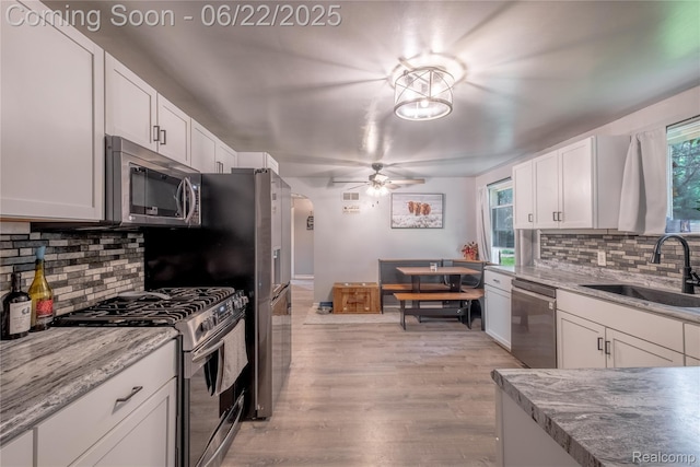 8780 Dixie Hwy, Birch Run, MI 48415 - kitchen with stainless steel appliances, backsplash, white cabinetry, and ceiling fan