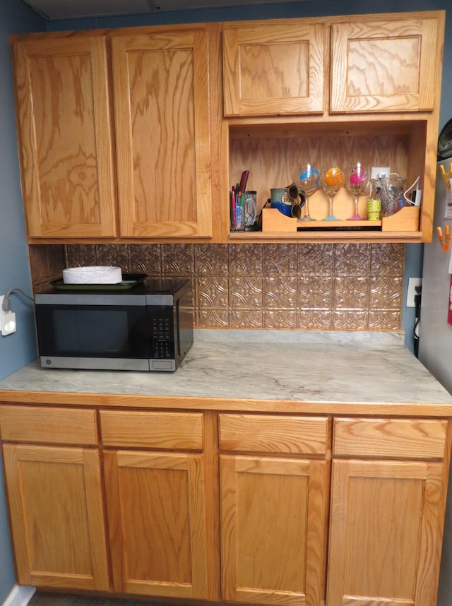 1513 Joy Ave, Jackson, MI 49203 - kitchen with stainless steel microwave, light countertops, open shelves, and tasteful backsplash