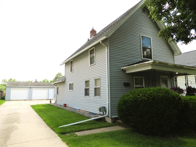 1513 Joy Ave, Jackson, MI 49203 - view of side of home featuring a chimney, an outdoor structure, a detached garage, a lawn, and roof with shingles
