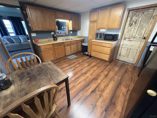 7408 Carleton Rd, Clayton, MI 49235 - kitchen with light countertops, black microwave, dark wood-style floors, and a drop ceiling