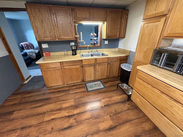 7408 Carleton Rd, Clayton, MI 49235 - kitchen featuring dark wood-style flooring, light countertops, a drop ceiling, and brown cabinets