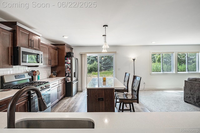 1013 Lancaster St, Lapeer, MI 48446 - kitchen with appliances with stainless steel finishes, healthy amount of natural light, dark brown cabinetry, decorative light fixtures, and recessed lighting