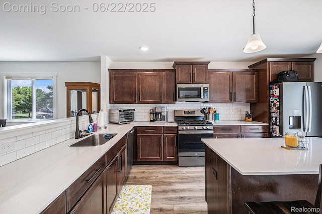 1013 Lancaster St, Lapeer, MI 48446 - kitchen featuring stainless steel appliances, light countertops, decorative backsplash, light wood-style floors, and dark brown cabinets