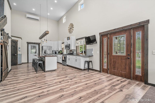 2539 Daisy Ln, Middleville, MI 49333 - kitchen featuring appliances with stainless steel finishes, dark countertops, a towering ceiling, a kitchen bar, and healthy amount of natural light