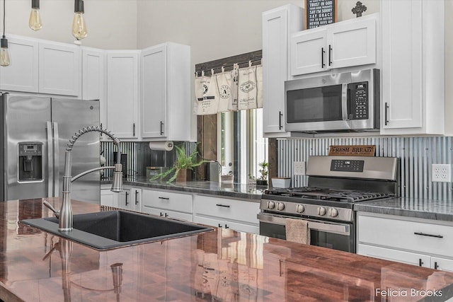 2539 Daisy Ln, Middleville, MI 49333 - kitchen with stainless steel appliances, white cabinets, dark stone countertops, pendant lighting, and tasteful backsplash