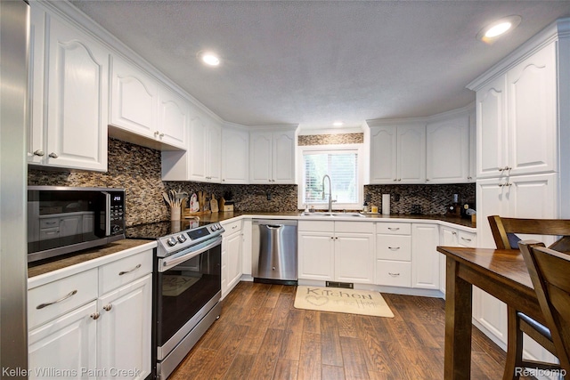 1320 W Drahner Rd, Oxford, MI 48371 - kitchen featuring appliances with stainless steel finishes, dark wood finished floors, white cabinetry, backsplash, and recessed lighting