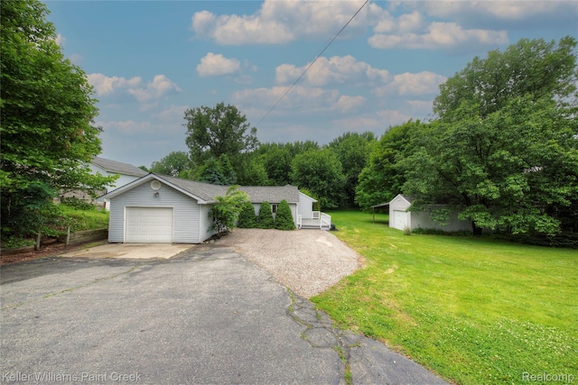 1320 W Drahner Rd, Oxford, MI 48371 - view of front facade with a front yard, driveway, a garage, and an outbuilding