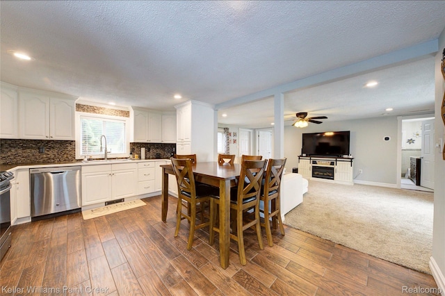 1320 W Drahner Rd, Oxford, MI 48371 - dining room with dark wood-type flooring, a ceiling fan, recessed lighting, a fireplace, and a textured ceiling