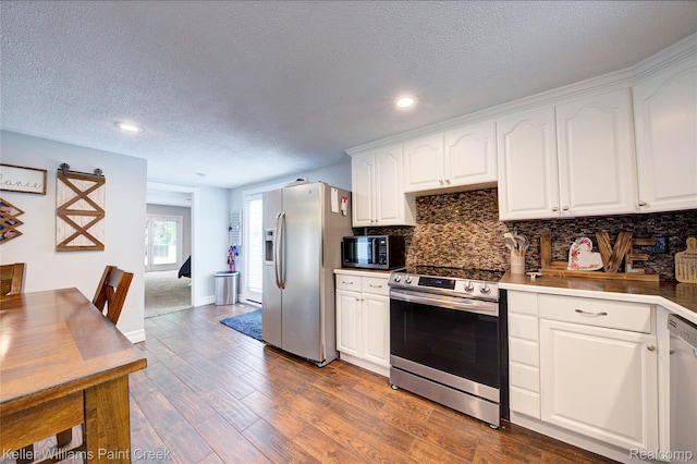 1320 W Drahner Rd, Oxford, MI 48371 - kitchen featuring stainless steel appliances, a textured ceiling, backsplash, white cabinetry, and dark wood-style flooring