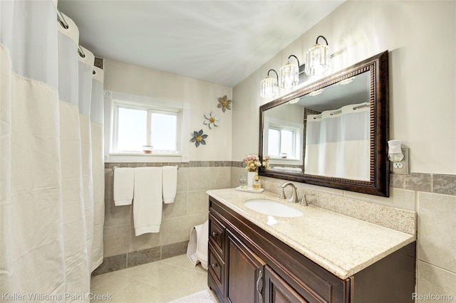 1320 W Drahner Rd, Oxford, MI 48371 - bathroom with tile walls, plenty of natural light, tile patterned flooring, vanity, and a wainscoted wall