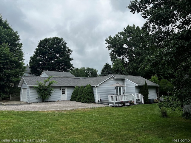 1320 W Drahner Rd, Oxford, MI 48371 - view of front facade featuring a front lawn, gravel driveway, a wooden deck, and a shingled roof