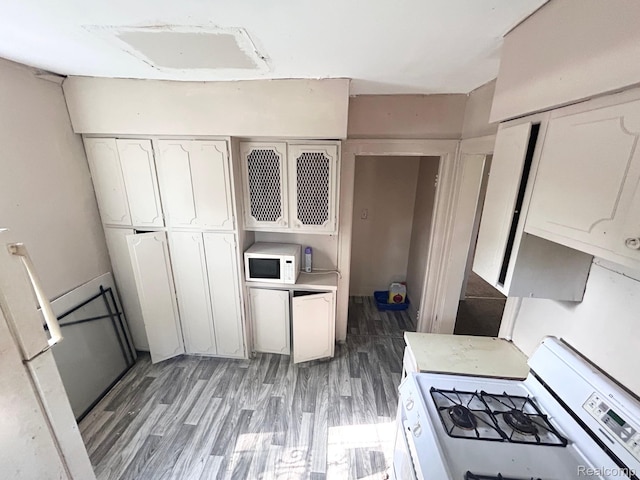 523 Grace St, Flint, MI 48503 - kitchen featuring white appliances, light wood finished floors, white cabinetry, and light countertops