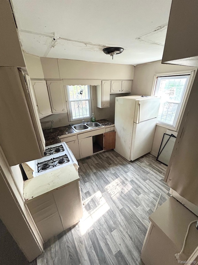 523 Grace St, Flint, MI 48503 - kitchen with freestanding refrigerator, light wood-type flooring, and white cabinets