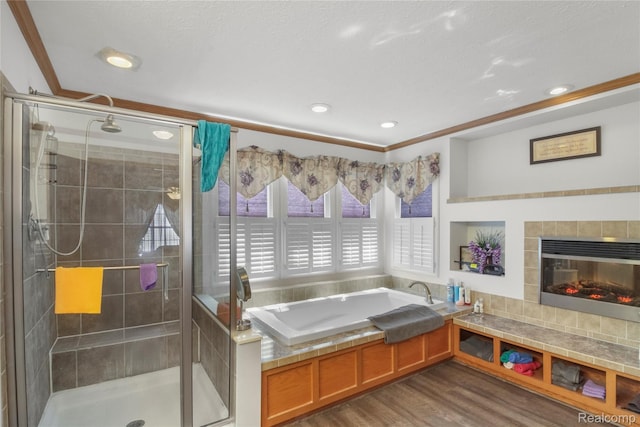 3933 Benjamin Way, Monroe, MI 48161 - bathroom featuring a garden tub, a shower stall, wood finished floors, recessed lighting, and a tile fireplace