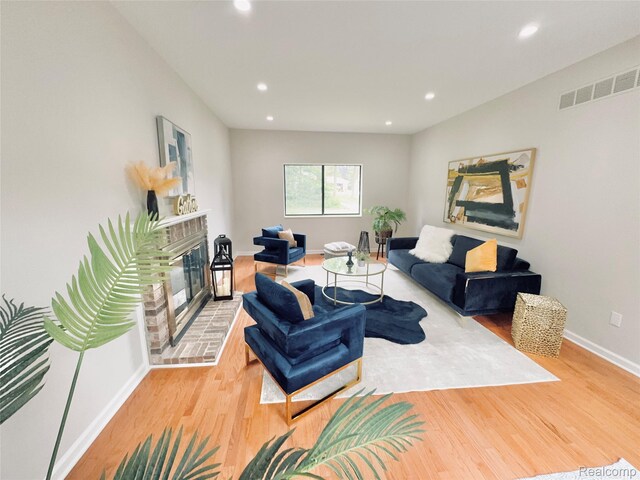 694 Robar Cir, Commerce Twp, MI 48386 - living room with light wood-type flooring, a glass covered fireplace, and recessed lighting