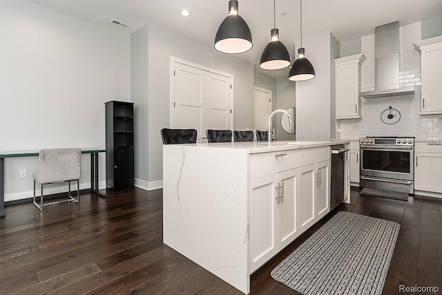 1021 S Washington Ave Unit G, Royal Oak, MI 48067 - kitchen featuring appliances with stainless steel finishes, wall chimney range hood, dark wood-style floors, tasteful backsplash, and recessed lighting