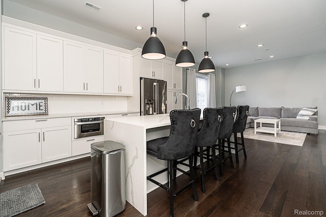 1021 S Washington Ave Unit G, Royal Oak, MI 48067 - kitchen with appliances with stainless steel finishes, dark wood-style flooring, recessed lighting, white cabinets, and a center island with sink
