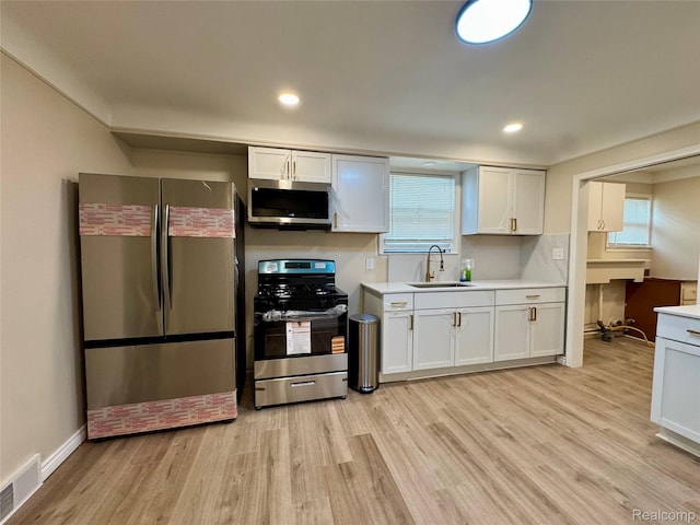 14276 Hobart Ave, Warren, MI 48089 - kitchen featuring stainless steel appliances, light wood-type flooring, light countertops, white cabinetry, and recessed lighting
