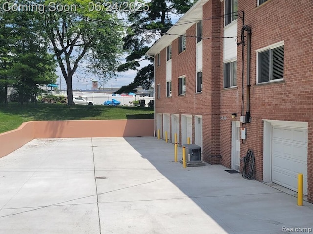 3400 Elizabeth Dr Unit 4, Trenton, MI 48183 - view of home's exterior featuring a garage, concrete driveway, and brick siding