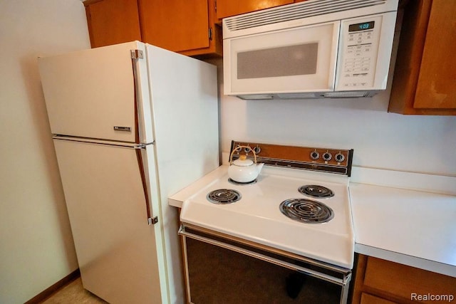 3400 Elizabeth Dr Unit 4, Trenton, MI 48183 - kitchen with white appliances, brown cabinets, and light countertops