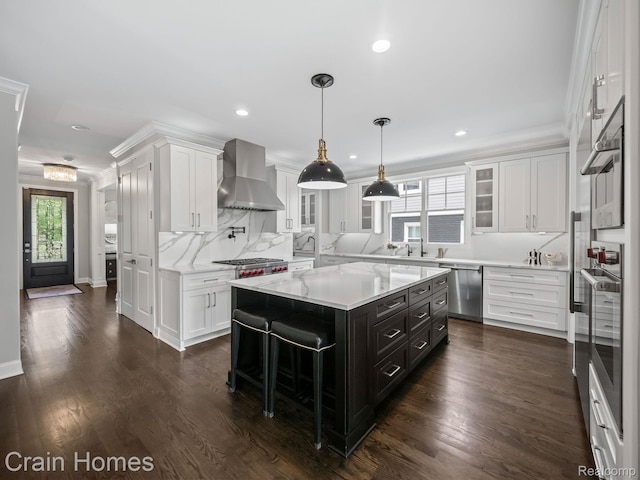 1790 Washington Blvd, Birmingham, MI 48009 - kitchen featuring wall chimney exhaust hood, appliances with stainless steel finishes, white cabinetry, glass insert cabinets, and ornamental molding