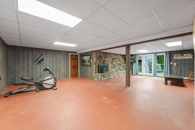 4301B W Sanborn Rd, Lake City, MI 49651 - workout room featuring a paneled ceiling, a wood stove, and wooden walls