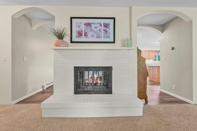 4301B W Sanborn Rd, Lake City, MI 49651 - detailed view of baseboard heating, a brick fireplace, carpet flooring, and arched walkways