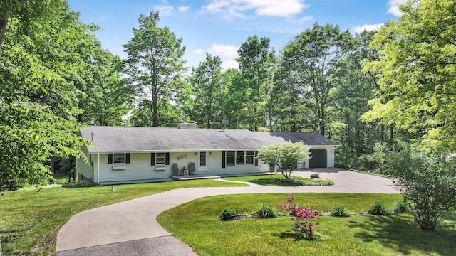 4301B W Sanborn Rd, Lake City, MI 49651 - ranch-style home with curved driveway, a garage, a front lawn, and a porch