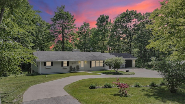 4301B W Sanborn Rd, Lake City, MI 49651 - ranch-style home with curved driveway, a front yard, a porch, and a garage