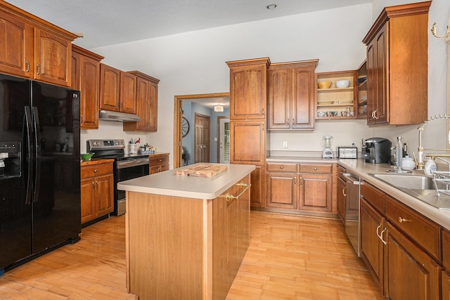 27418 Orchard Dr, Sturgis, MI 49091 - kitchen with appliances with stainless steel finishes, under cabinet range hood, light wood finished floors, light countertops, and a kitchen island
