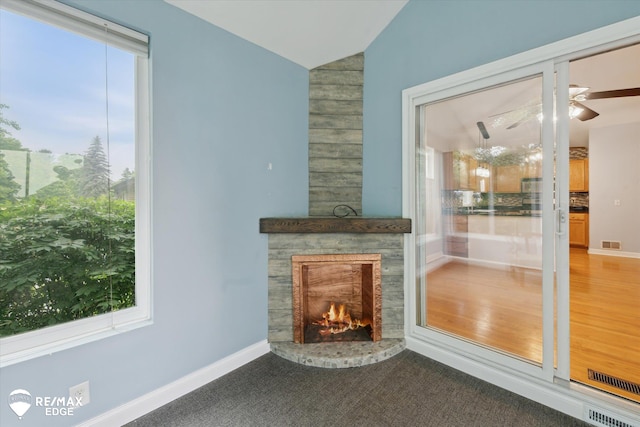 11419 Autumn Breeze Trl, Clio, MI 48420 - unfurnished living room with vaulted ceiling, plenty of natural light, a ceiling fan, and a lit fireplace