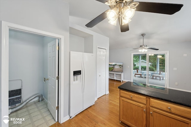 11419 Autumn Breeze Trl, Clio, MI 48420 - kitchen featuring white refrigerator with ice dispenser, ceiling fan, brown cabinetry, light floors, and dark stone counters