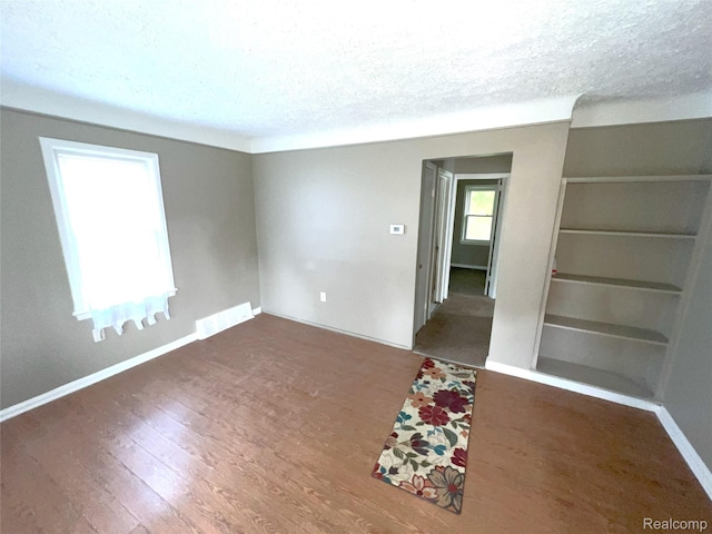 182 Crystal Lake Dr, Pontiac, MI 48341 - empty room featuring a textured ceiling, wood finished floors, and built in shelves