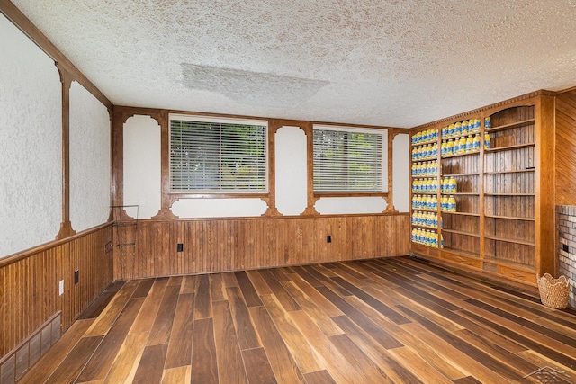4918 Frontier Ln, Saginaw, MI 48603 - spare room featuring wood finished floors, a textured ceiling, wood walls, and a wainscoted wall