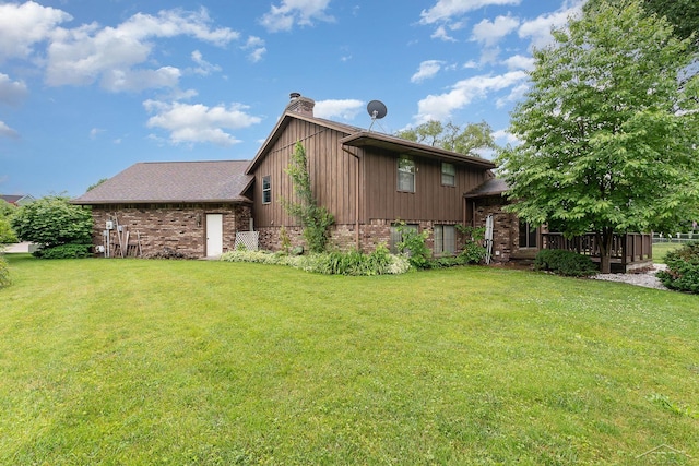 4918 Frontier Ln, Saginaw, MI 48603 - view of side of property featuring a chimney, brick siding, and a yard