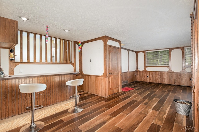 4918 Frontier Ln, Saginaw, MI 48603 - kitchen with a textured ceiling, wood finished floors, wooden walls, and a wainscoted wall