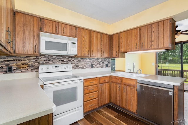 4918 Frontier Ln, Saginaw, MI 48603 - kitchen featuring white appliances, light countertops, a peninsula, and dark wood-style flooring