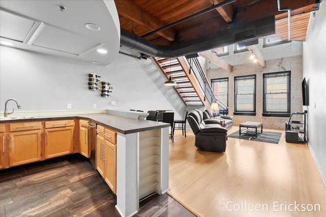600 Monroe Ave NW Unit 409, Grand Rapids, MI 49503 - kitchen with dark wood finished floors, a wood ceiling with exposed beams, a peninsula, brick wall, and open floor plan