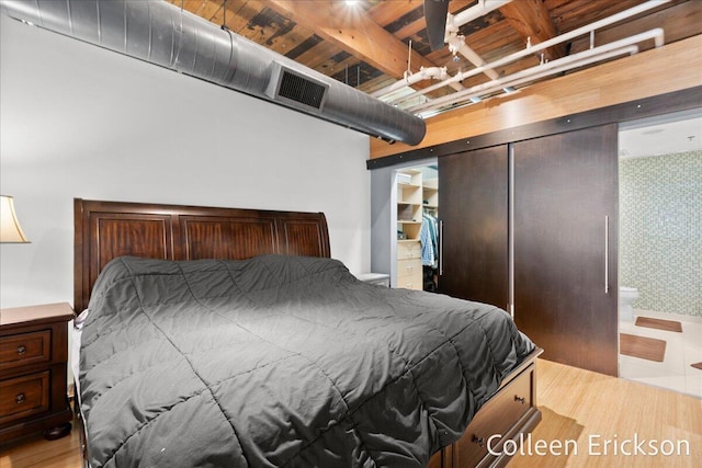 600 Monroe Ave NW Unit 409, Grand Rapids, MI 49503 - bedroom with wood finished floors, wallpapered walls, a closet, and beamed ceiling
