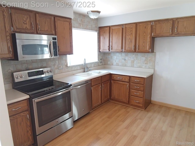 8283 Christine St, Warren, MI 48093 - kitchen with appliances with stainless steel finishes, brown cabinets, backsplash, and light wood-style floors