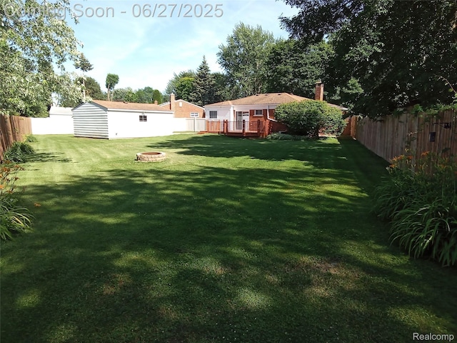 8283 Christine St, Warren, MI 48093 - fenced backyard with a wooden deck, an outdoor fire pit, and an outbuilding