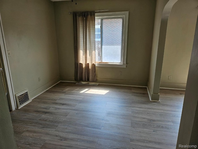 1102 W Atherton Rd W, Flint, MI 48507 - empty room with arched walkways and wood finished floors