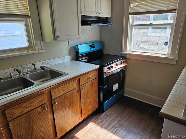 1102 W Atherton Rd W, Flint, MI 48507 - kitchen with stainless steel range with electric cooktop, under cabinet range hood, dark wood-style flooring, and healthy amount of natural light