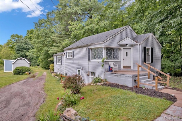 4155 Mill Lake Rd, Lake Orion, MI 48360 - view of front facade featuring a front lawn, roof with shingles, view of scattered trees, and an outdoor structure