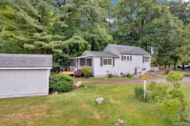 4155 Mill Lake Rd, Lake Orion, MI 48360 - view of front of home featuring a sunroom, a front lawn, view of scattered trees, and a storage shed