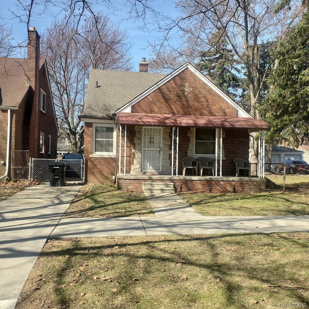 20215 Stotter St, Detroit, MI 48234 - bungalow-style home featuring covered porch, brick siding, a chimney, and a gate