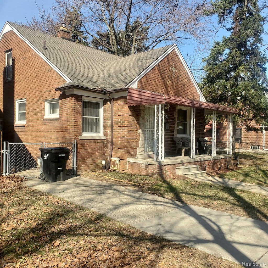 20215 Stotter St, Detroit, MI 48234 - rear view of house with covered porch, brick siding, roof with shingles, a chimney, and a gate