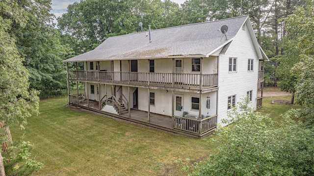 8867 W Garfield Rd, Shelby, MI 49455 - back of house featuring a shingled roof, a lawn, a wooden deck, and view of scattered trees
