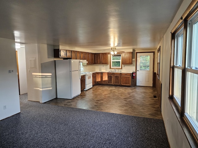 8867 W Garfield Rd, Shelby, MI 49455 - kitchen featuring white appliances, light countertops, ceiling fan, under cabinet range hood, and stone finish floors